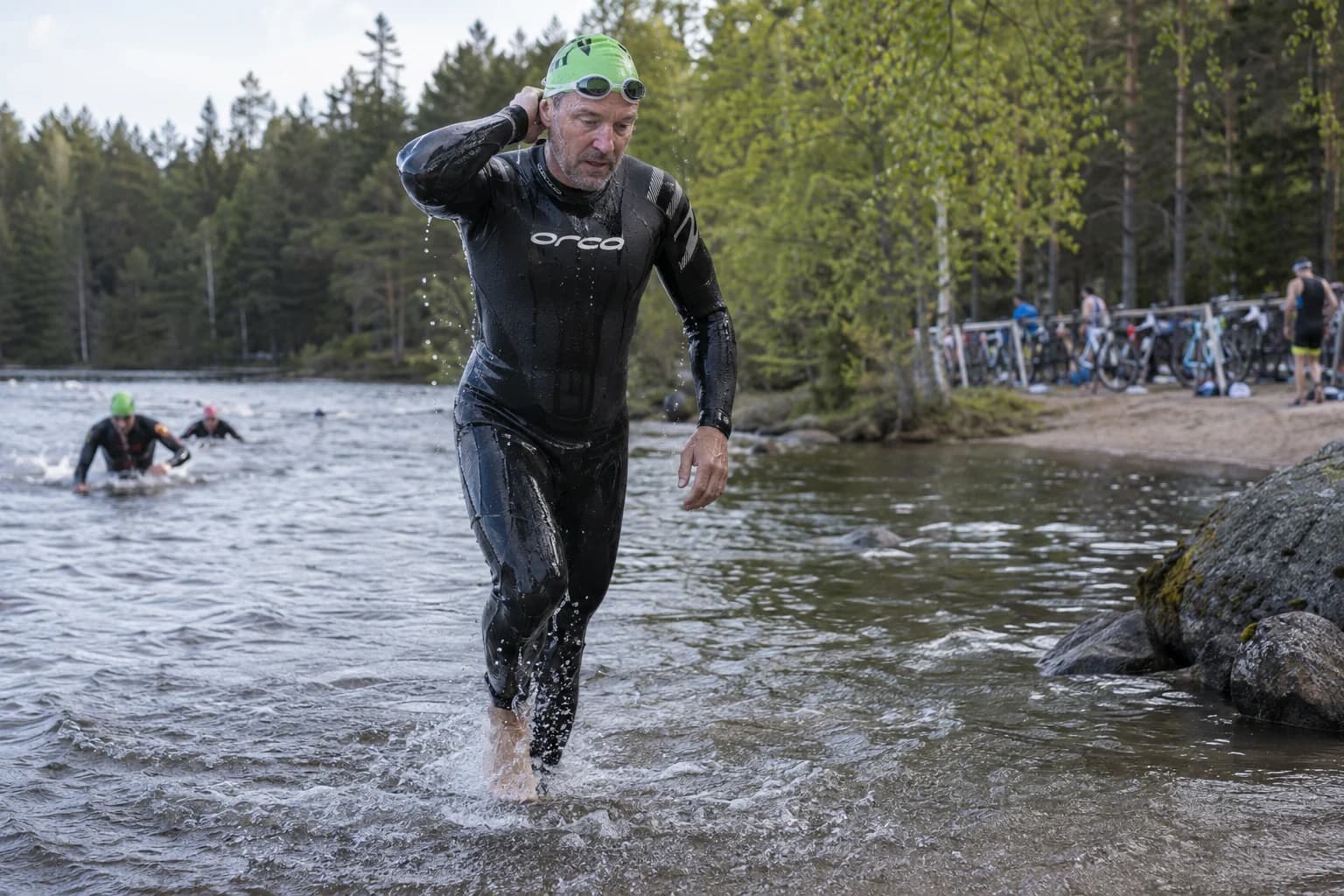 AI-gegenereerd sfeerbeeld: triatleet die uit een meer naar de wisselzone rent