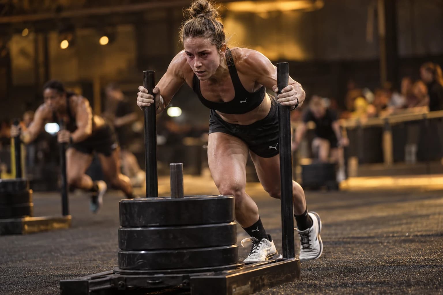 AI-gegenereerd sfeerbeeld: atlete die een slee naar voren duwt onder amberkleurig licht
