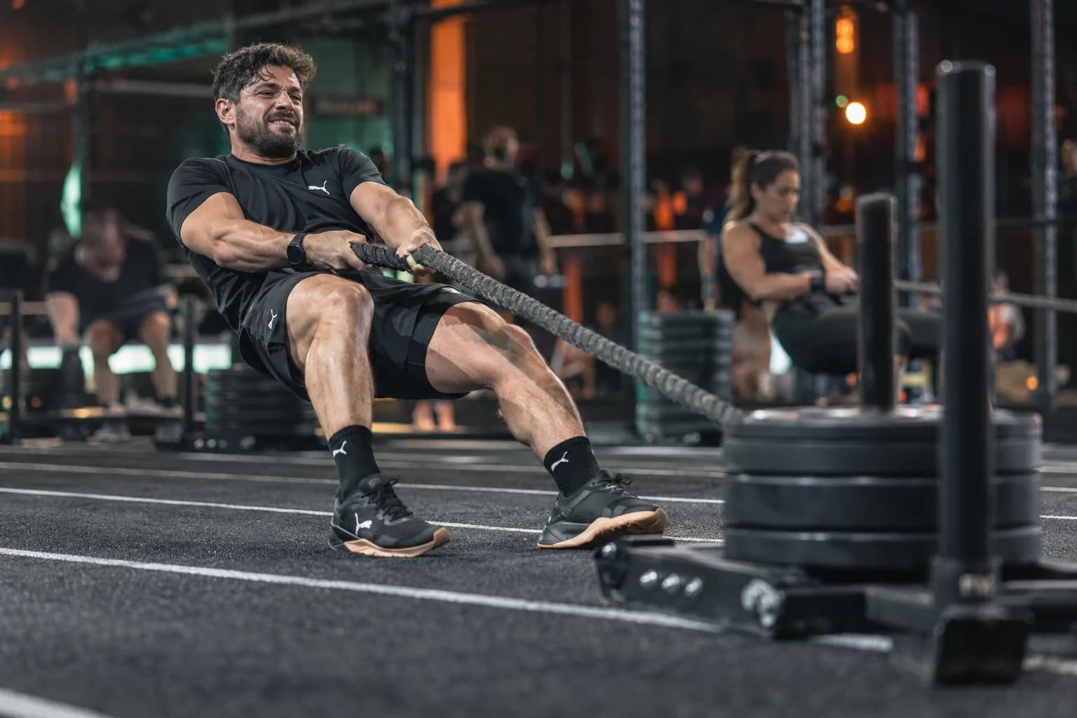 AI-gegenereerd sfeerbeeld: atleet bij een sled pull in oranje en groen arenalicht